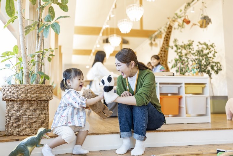 パペットで女の子をあやしている女性スタッフ