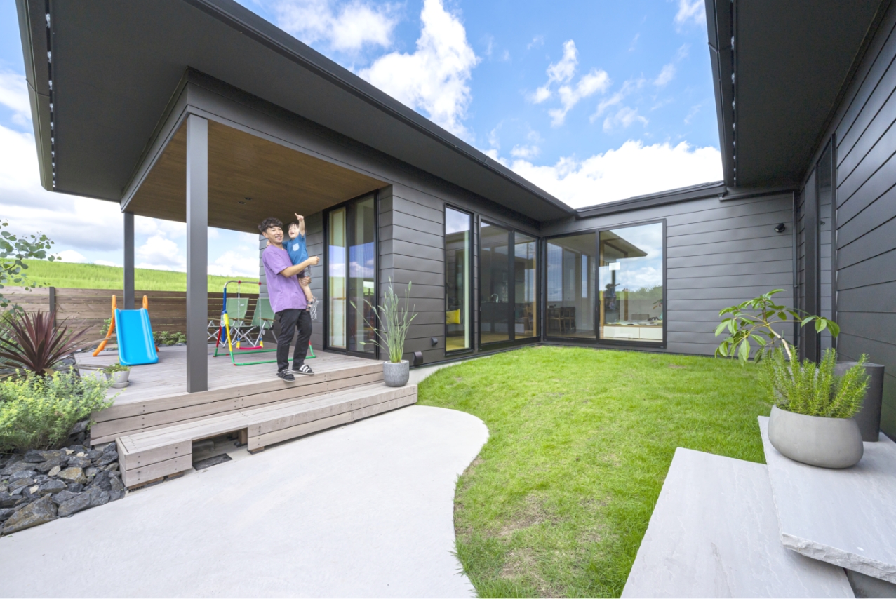 ウッドデッキで子どもを抱き上げている男性