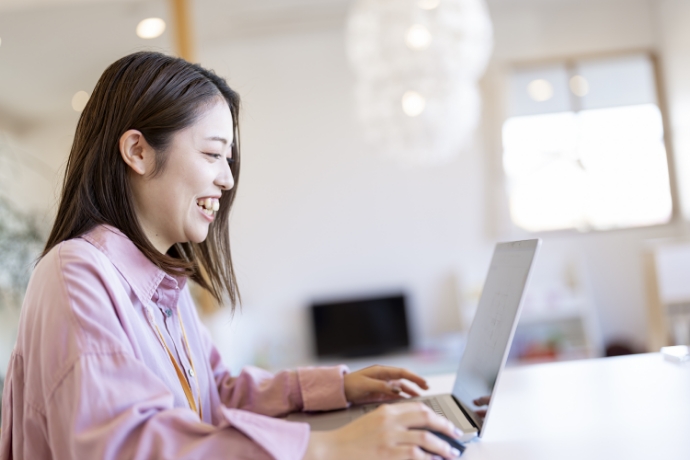 笑いながらパソコンの画面を見ている女性スタッフ