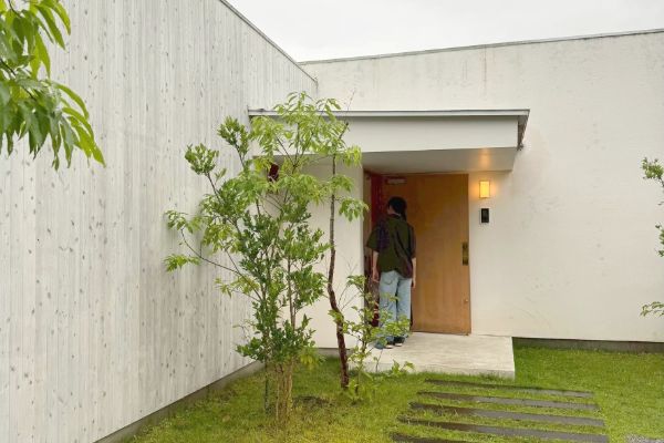 玄関から家の中を見ている男性