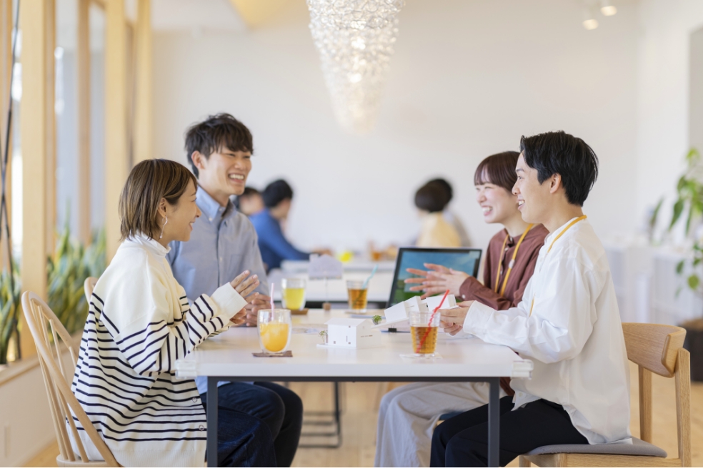 同じ机で談笑している社員4人