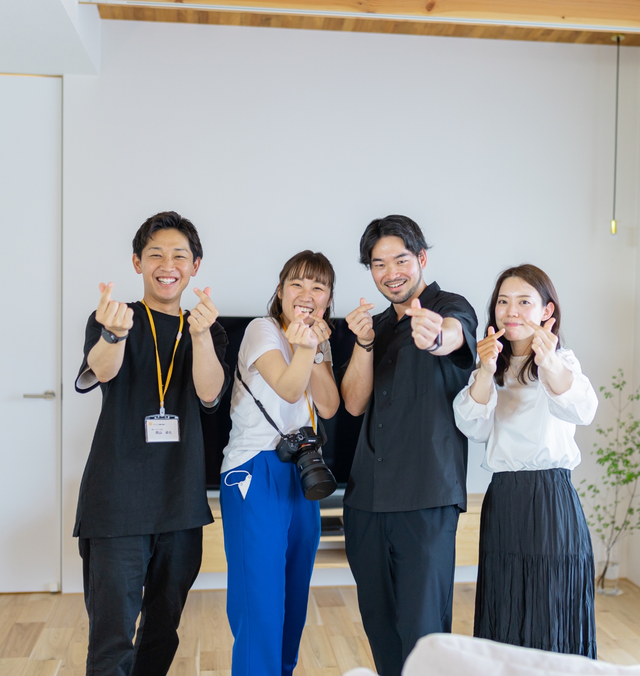 指ハートをしている男女4人の社員