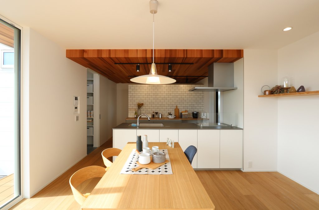 レッドシダ―天井のあるキッチン。白いキッチンはトクラスのもの。